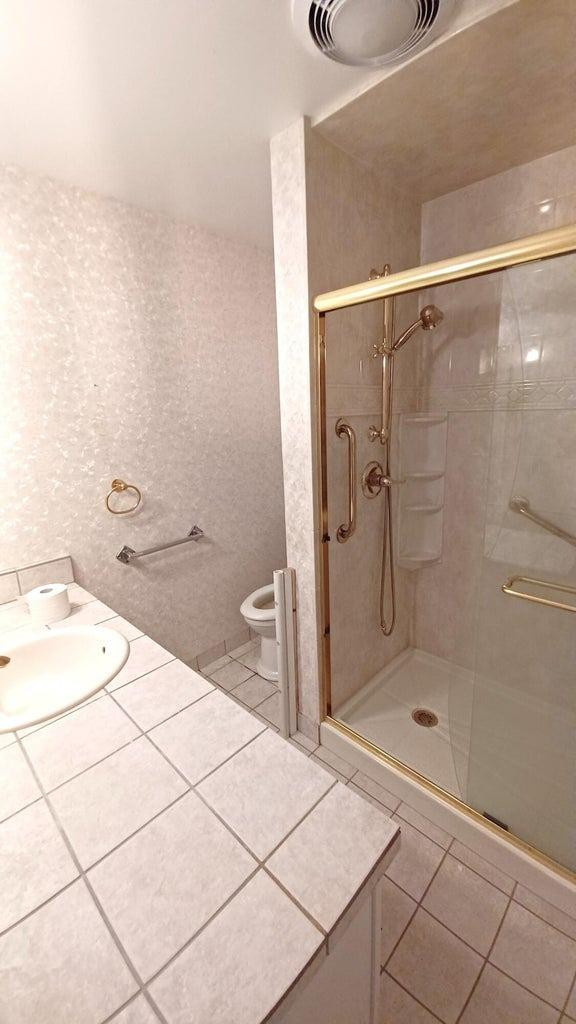 206 South W 7th Street Lockney, TX 79241 - Photo 25 of 47 a bathroom with a granite countertop sink a toilet and shower