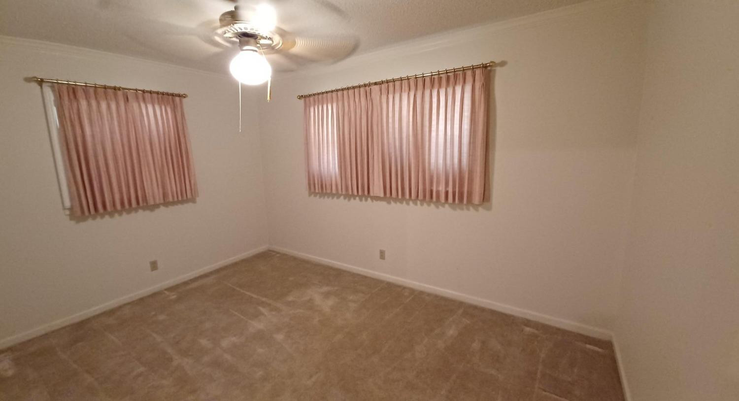 206 South W 7th Street Lockney, TX 79241 - Photo 34 of 47 an empty room with windows and fan