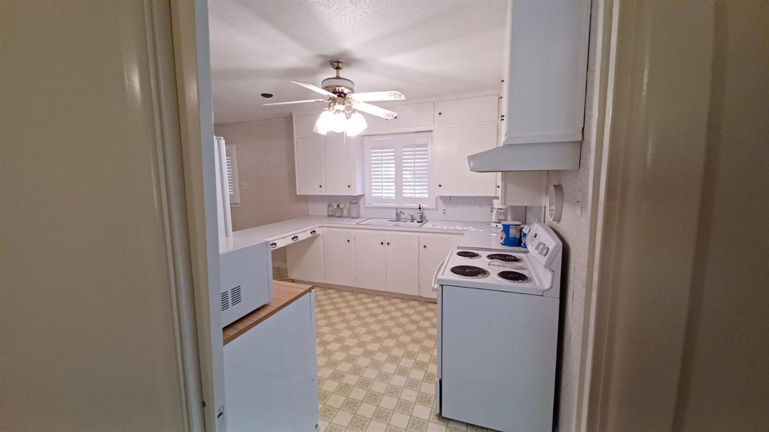 206 South W 7th Street Lockney, TX 79241 - Photo 8 of 47 a kitchen with a sink cabinets stainless steel appliances and a chandelier