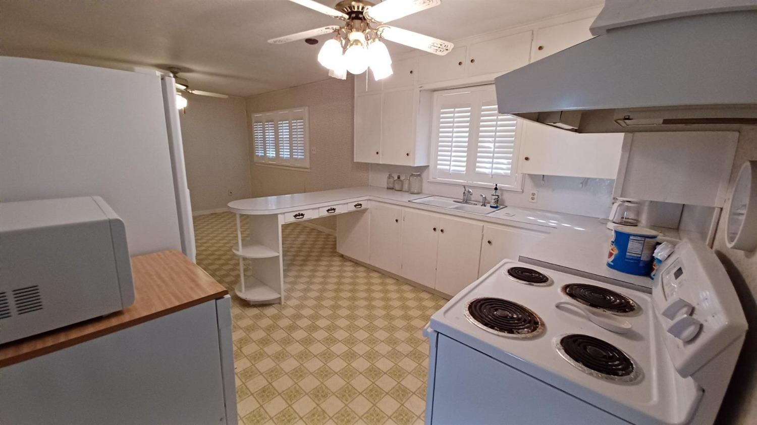 206 South W 7th Street Lockney, TX 79241 - Photo 9 of 47 a kitchen with a sink a stove a microwave and a refrigerator