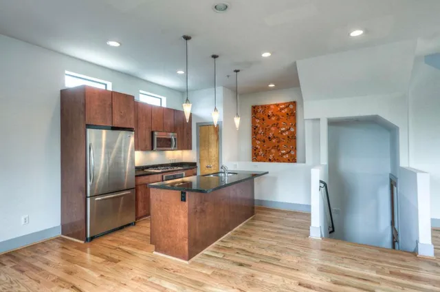 a kitchen with stainless steel appliances granite countertop a refrigerator and a sink