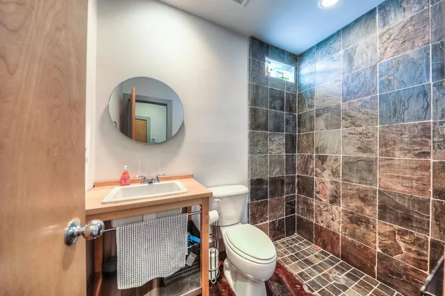 a bathroom with a sink mirror toilet and shower