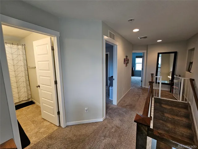 a view of a hallway with furniture and floor to ceiling window