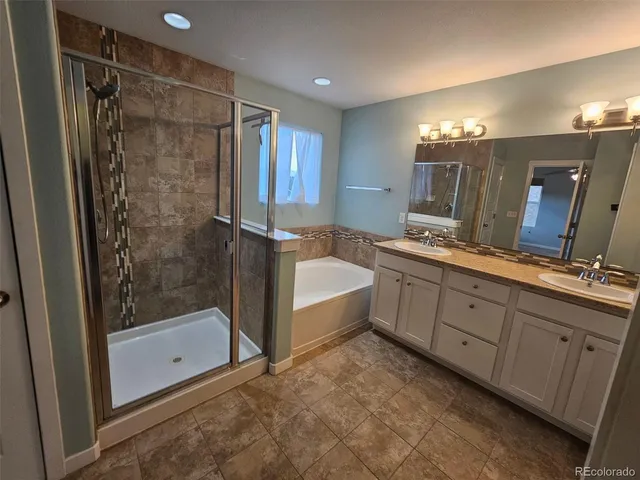 a bathroom with a tub sink and mirror