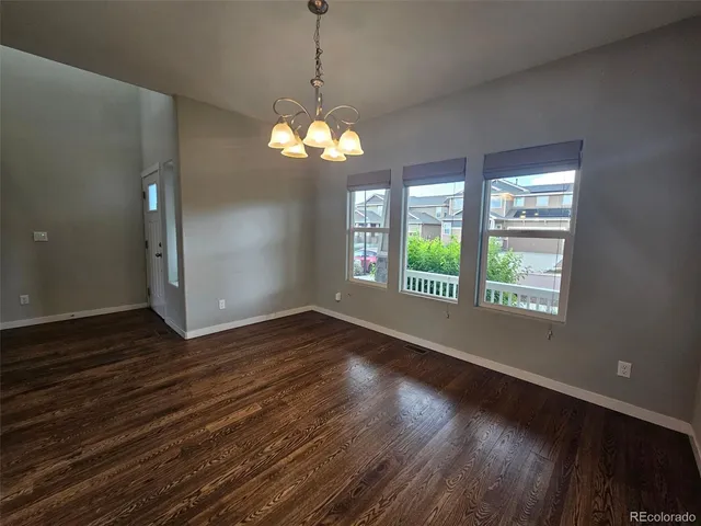 a view of a room with wooden floors and chandelier
