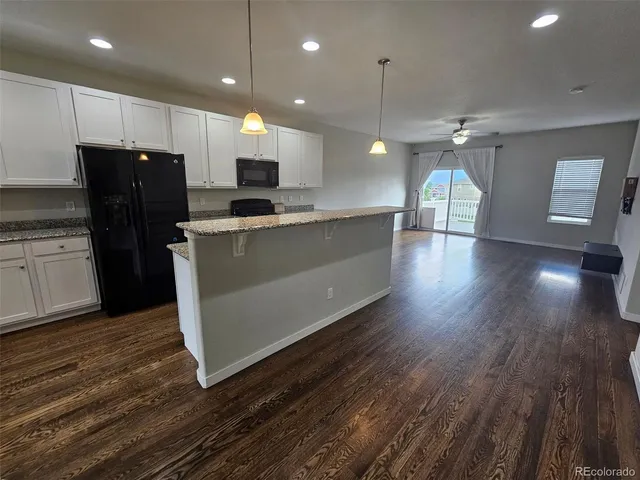 a kitchen with stainless steel appliances granite countertop a refrigerator a sink and a stove