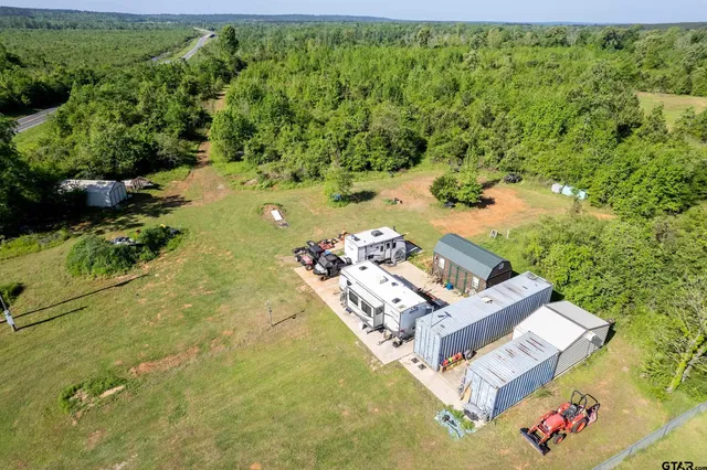 an aerial view of a house with a yard swimming pool and outdoor seating