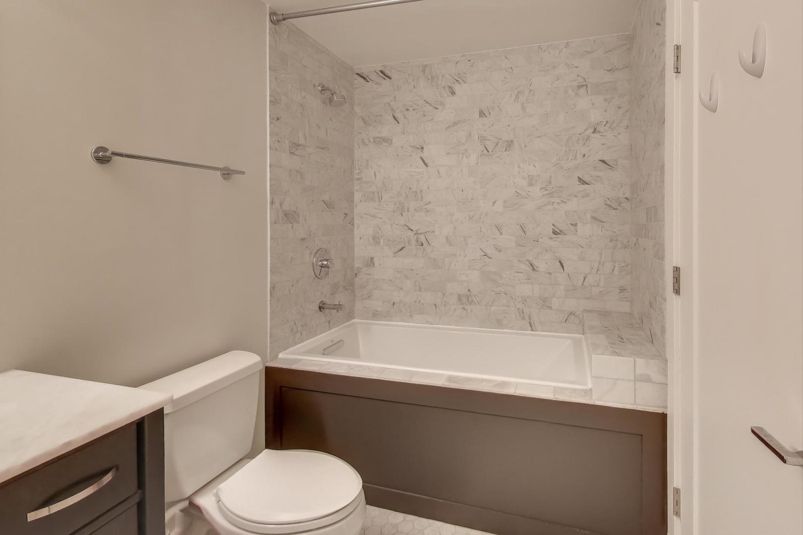 1301 West Madison Street, Unit 315 Chicago, IL 60607 - Photo 16 of 27 a bathroom with a bathtub and toilet