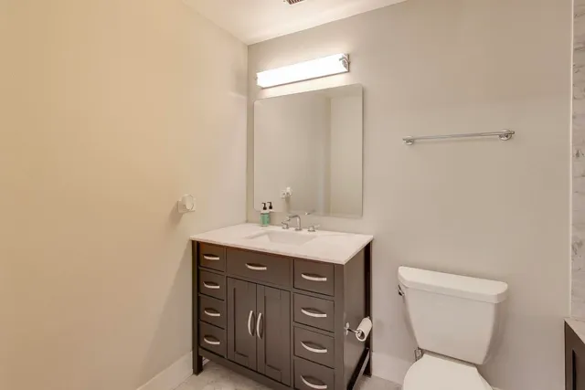 a bathroom with a toilet a sink and mirror