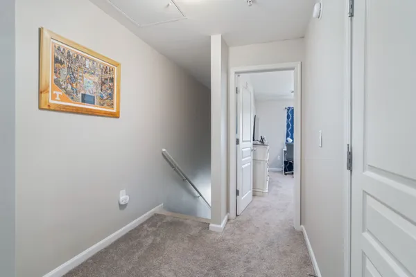 a view of a hallway with closet and a view of bathroom