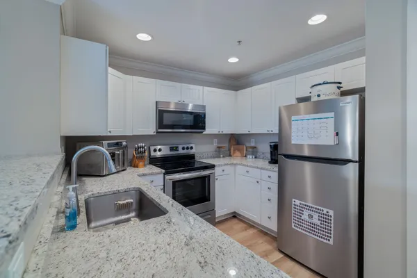 a kitchen with a refrigerator sink and stove top oven