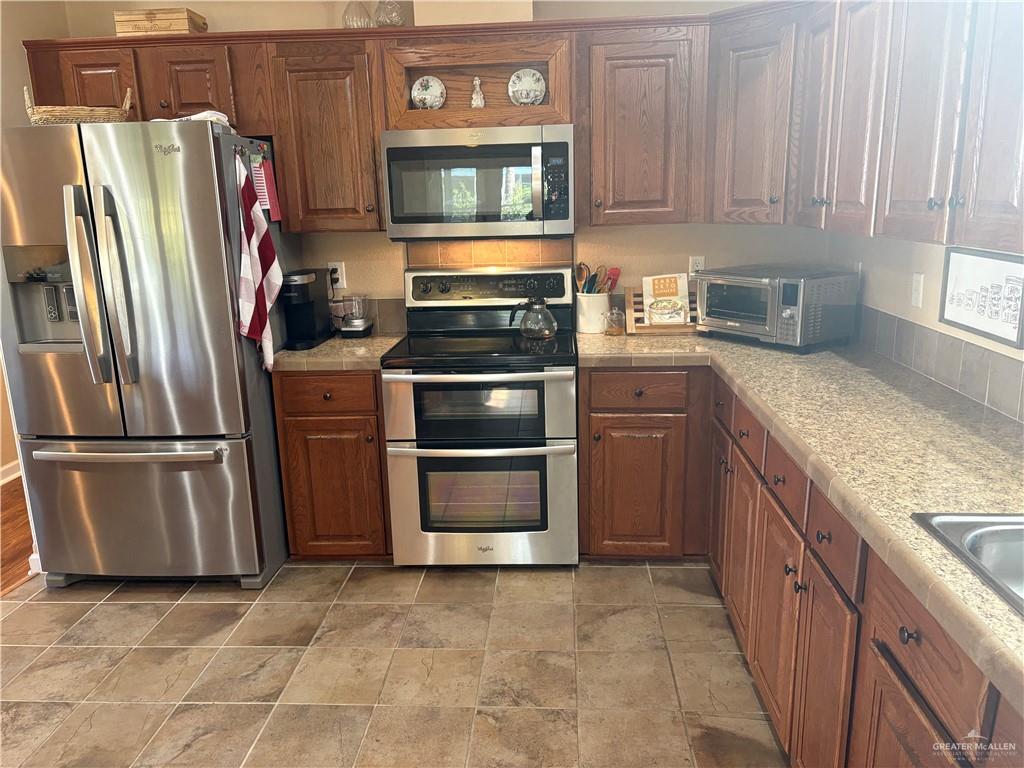 3078 Durango Street Mercedes, TX 78570 - Photo 18 of 41 a kitchen with stainless steel appliances granite countertop a refrigerator stove and sink