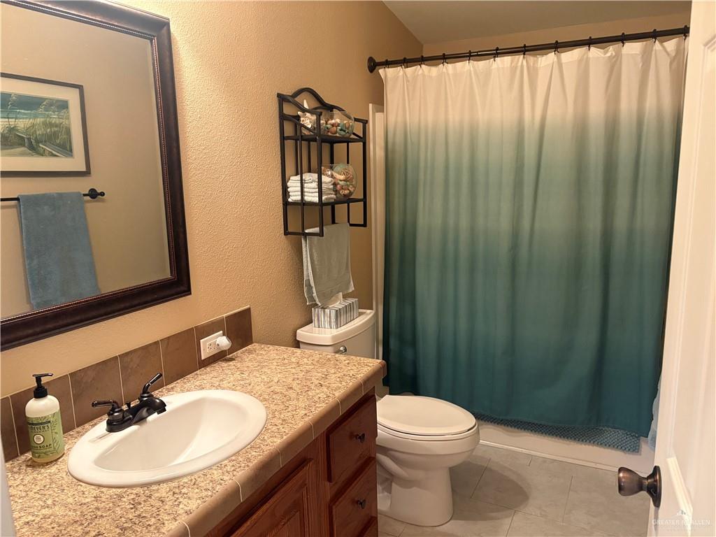 3078 Durango Street Mercedes, TX 78570 - Photo 29 of 41 a bathroom with a granite countertop sink toilet and shower