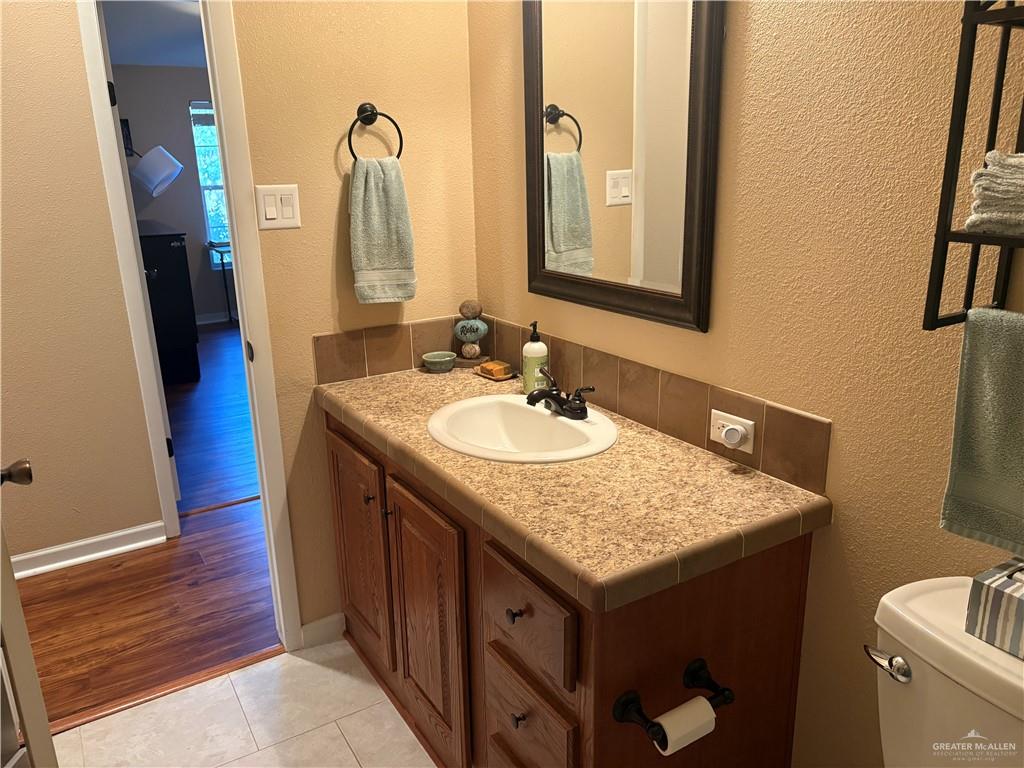 3078 Durango Street Mercedes, TX 78570 - Photo 30 of 41 a bathroom with a granite countertop sink and a mirror