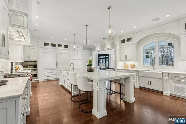 a living room with couches a flat screen tv and kitchen view