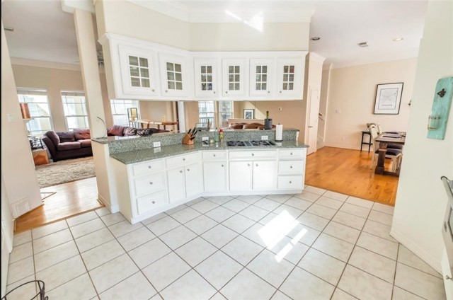 3011 Houston Avenue, Unit B Houston, TX 77009 - Photo 15 of 24 a large white kitchen with granite countertop a sink white cabinets and a stove