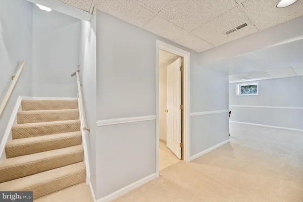 a view of a brick house next to a yard with large trees