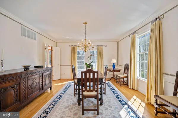 a dining room with furniture wooden floor a chandelier and a rug