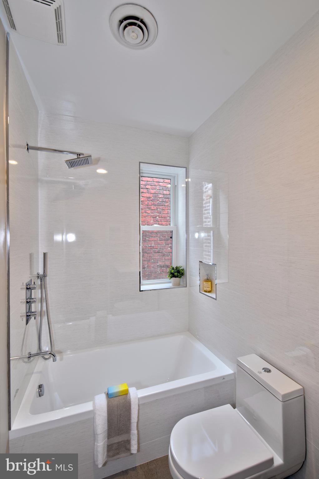 238 10th Street Northeast Washington, DC 20002 - Photo 23 of 30 a bathroom with a bathtub shower sink vanity and toilet