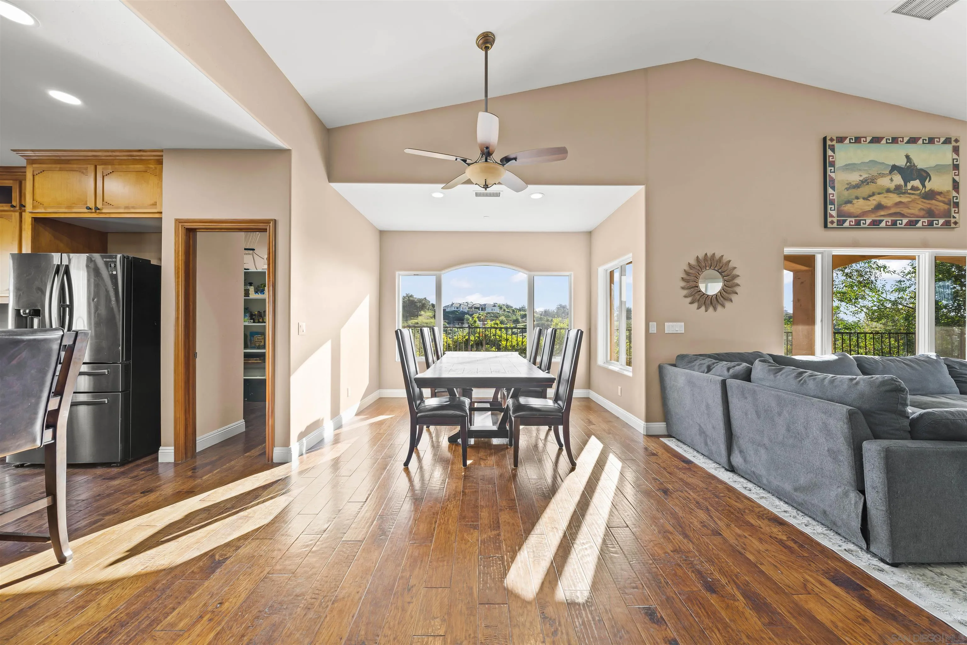 16951 Old Coach Road Poway, CA 92064 - Photo 17 of 70 a dining room with wooden floor a chandelier a glass table and chairs