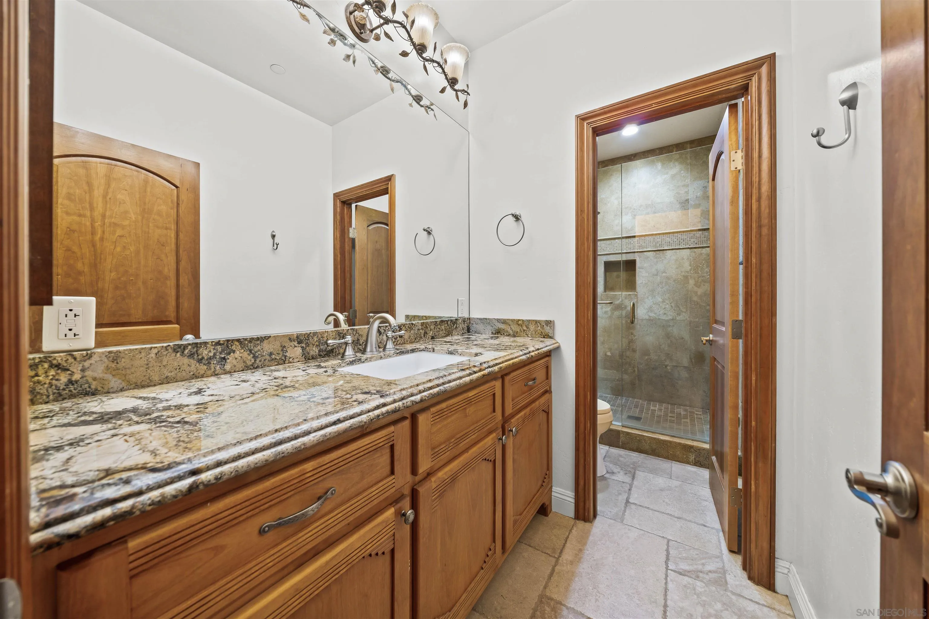 16951 Old Coach Road Poway, CA 92064 - Photo 39 of 70 a bathroom with a granite countertop sink a mirror and a shower