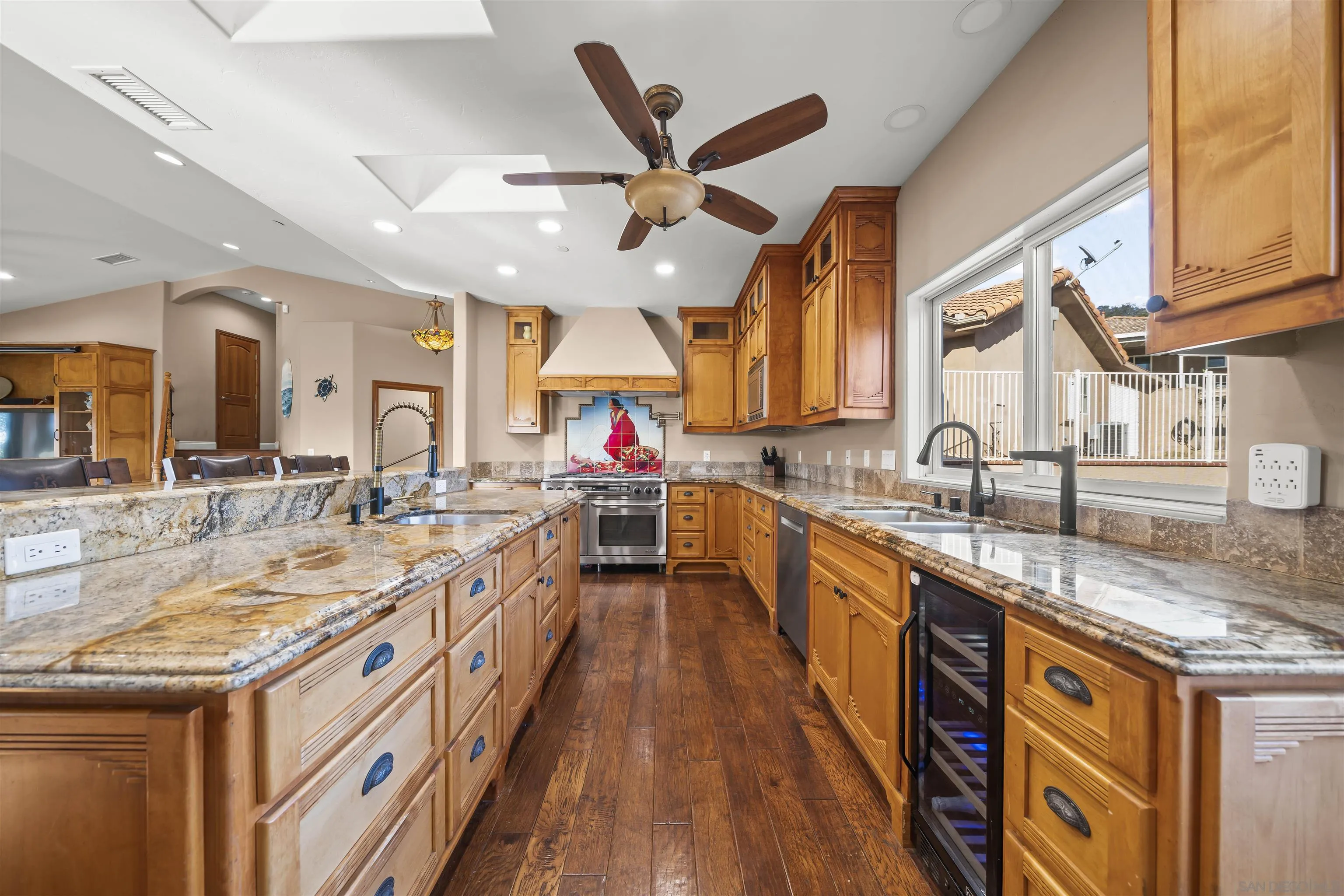 16951 Old Coach Road Poway, CA 92064 - Photo 6 of 70 a large kitchen with stainless steel appliances granite countertop a sink and dishwasher a stove with wooden floor