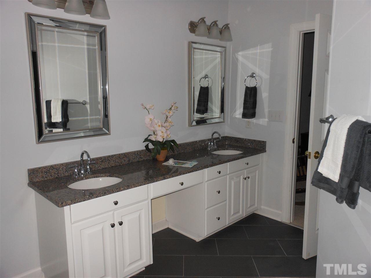 8409 Yucca Trail Raleigh, NC 27615 - Photo 16 of 25 a bathroom with double vanity and a mirror