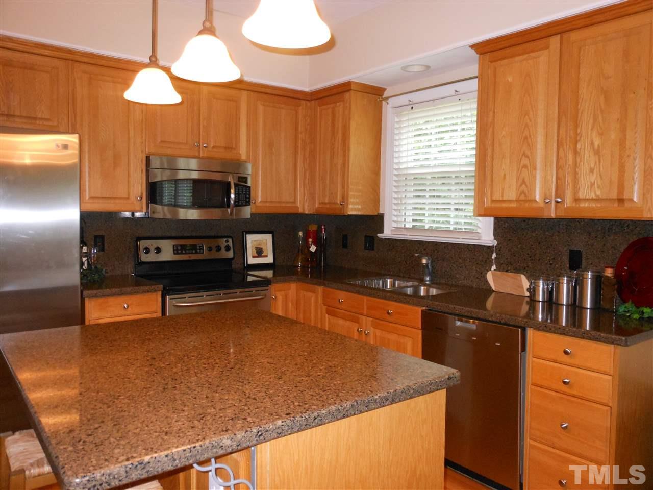 8409 Yucca Trail Raleigh, NC 27615 - Photo 6 of 25 a kitchen with stainless steel appliances granite countertop a sink a stove and a microwave