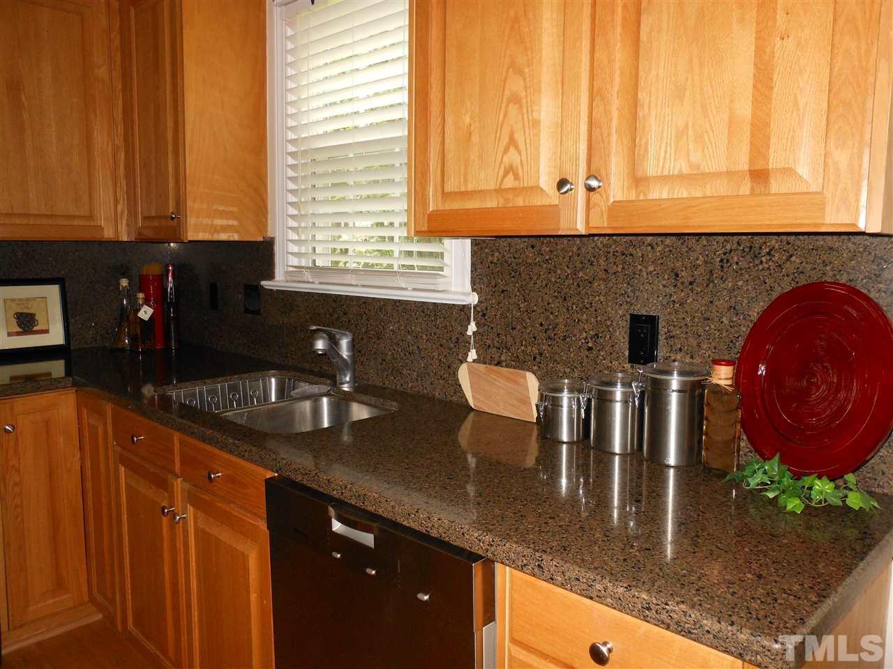 8409 Yucca Trail Raleigh, NC 27615 - Photo 7 of 25 a kitchen with granite countertop a sink a stove and cabinets