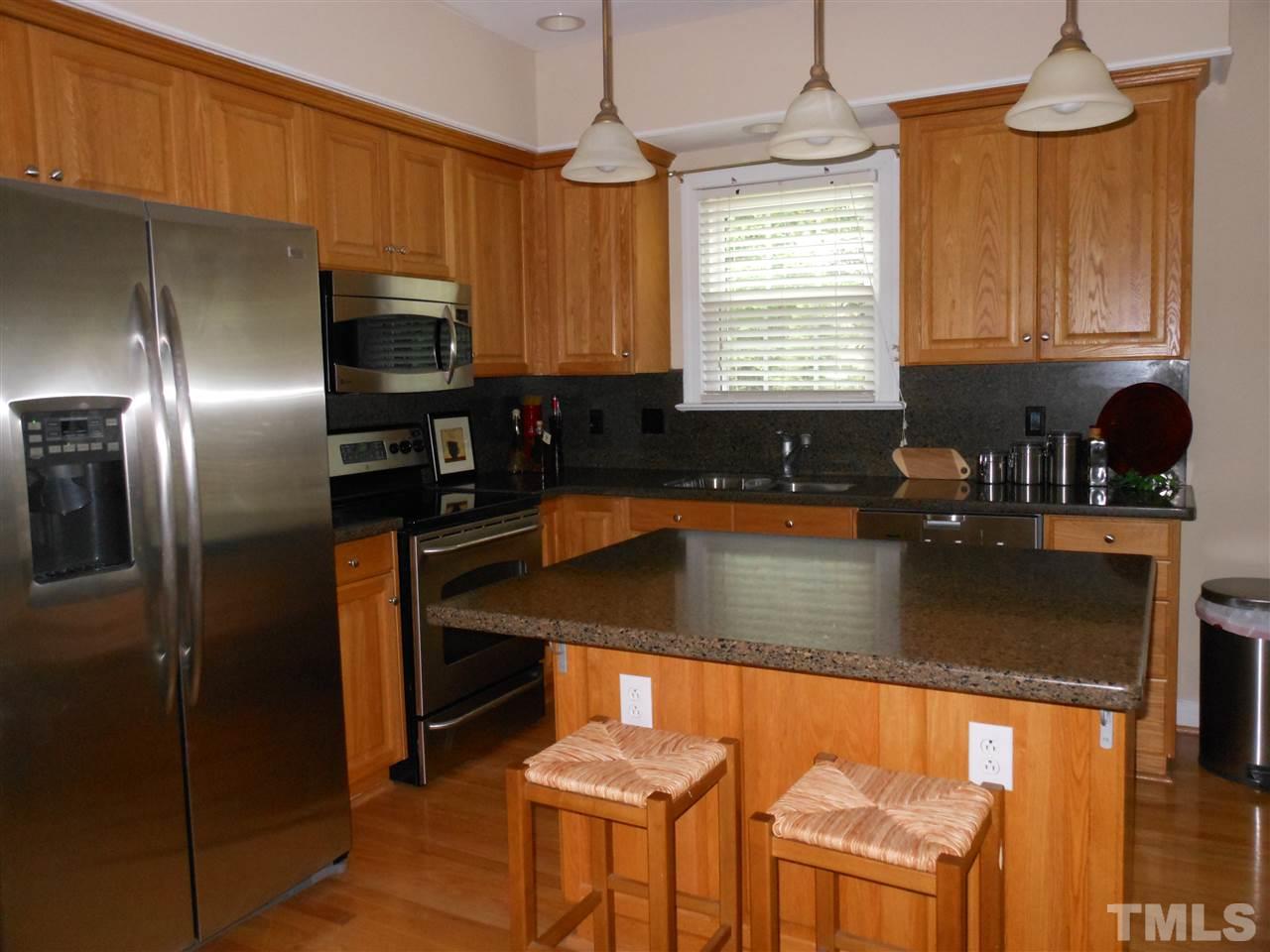 8409 Yucca Trail Raleigh, NC 27615 - Photo 8 of 25 a kitchen with stainless steel appliances granite countertop a sink refrigerator and microwave