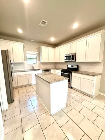 a kitchen with stainless steel appliances granite countertop a stove a sink a microwave a counter top and cabinets