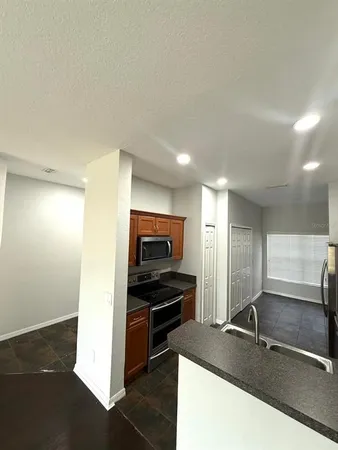 a kitchen with granite countertop a refrigerator and a sink
