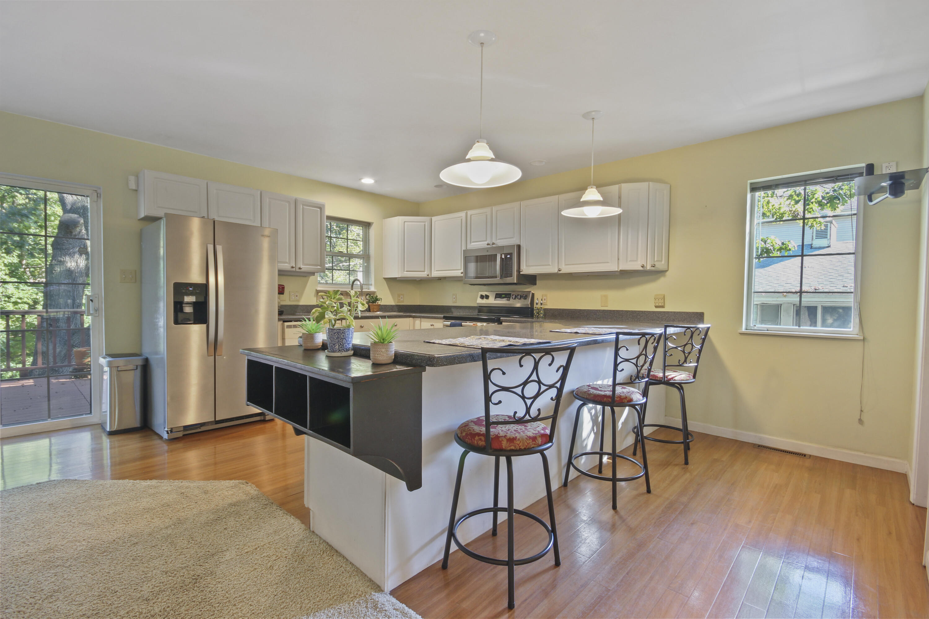 739 Montgomery Street Gary, IN 46403 - Photo 10 of 34 a open kitchen with stainless steel appliances granite countertop a stove a refrigerator a kitchen island a dining table and chairs with wooden floor