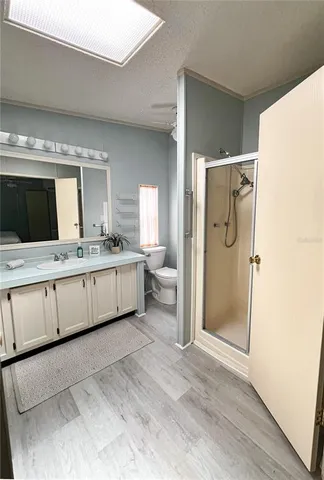 a spacious bathroom with a double vanity sink a mirror and a shower