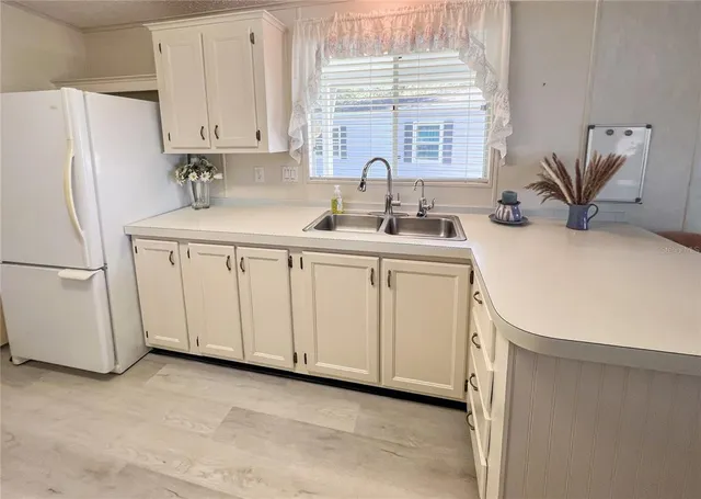 a kitchen with white cabinets and white appliances