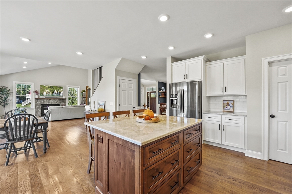 112 Nourse Road Bolton, MA 01740 - Photo 8 of 42 a kitchen with stainless steel appliances granite countertop a table chairs and a refrigerator