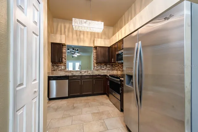 a kitchen with stainless steel appliances granite countertop a refrigerator and a stove