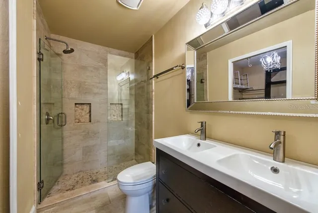 a bathroom with a double vanity sink toilet and shower