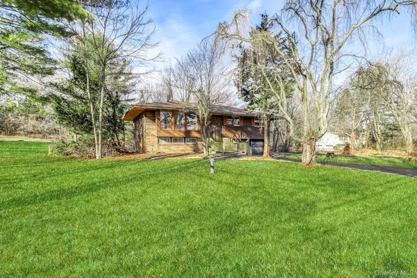 a view of a house with backyard and a tree
