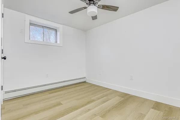 an empty room with a window and a ceiling fan