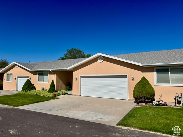 445 Topaz Boulevard, Unit 10 Delta, UT 84624 - Photo 1 of 28 Single story home featuring a garage, concrete driveway, a front yard, and stucco siding