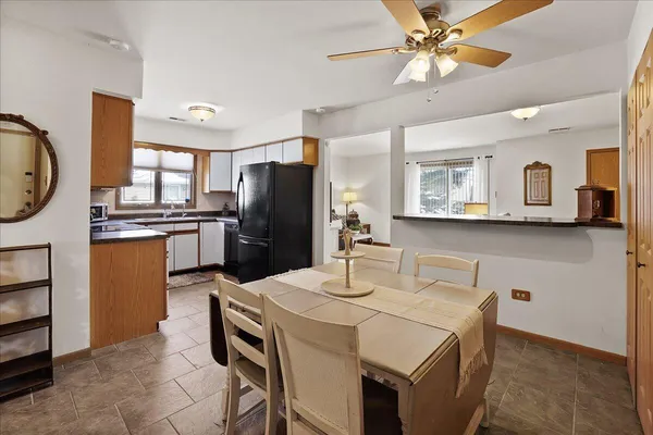 a kitchen with stainless steel appliances a table chairs and refrigerator