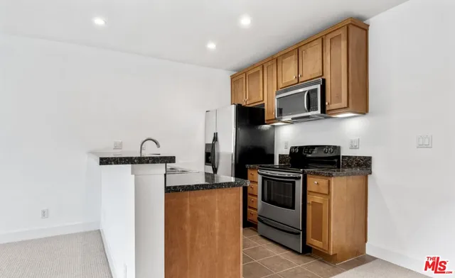 a kitchen with stainless steel appliances granite countertop a stove a microwave and a refrigerator