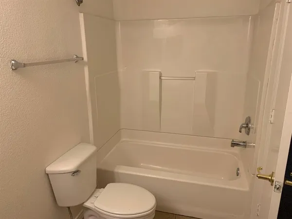 a bathroom with a toilet and a bath tub