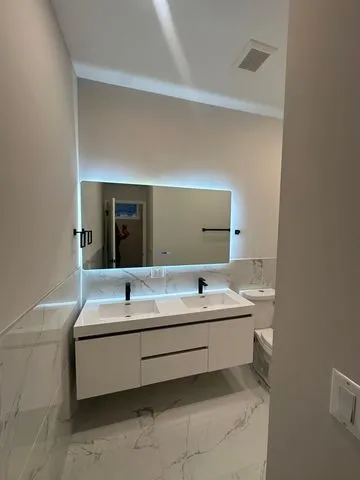 a bathroom with a double vanity sink and mirror