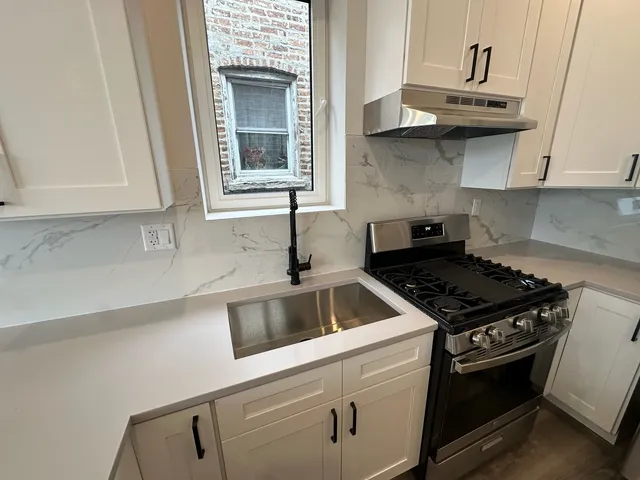 a kitchen with stainless steel appliances granite countertop a sink and a stove