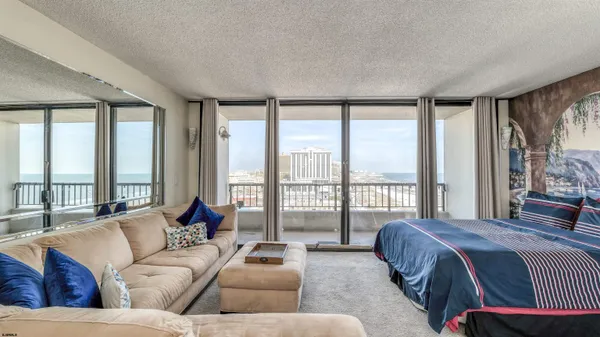 a spacious bedroom with a bed couch and a large window