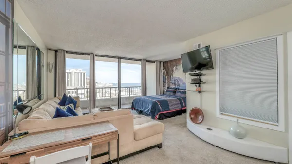 a living room with furniture a flat screen tv and large window