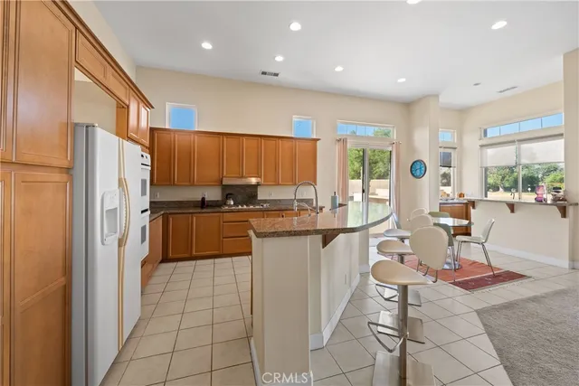 a kitchen with stainless steel appliances granite countertop a refrigerator and a stove top oven