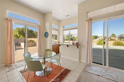 a dining room with furniture and a floor to ceiling window